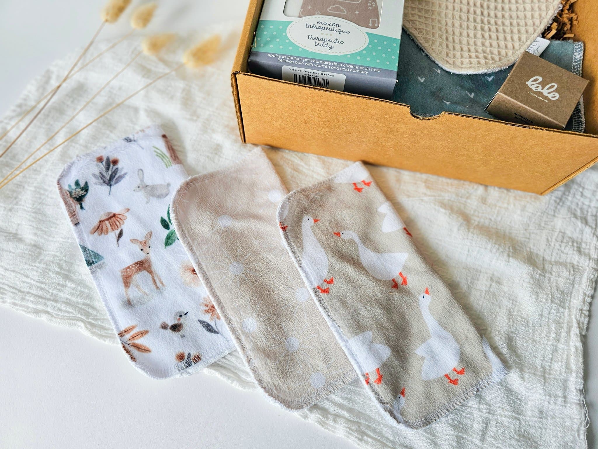 Ensemble de débarbouillettes douces aux motifs variés pour bébé faites par Shop moi ça, incluses dans la boîte cadeau Petit trésor, parfait pour la routine bain et soins des tout-petits.