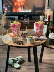 Soirée cinéma maison avec popcorn, bonbons, chocolat et verres de vin devant la télévision
